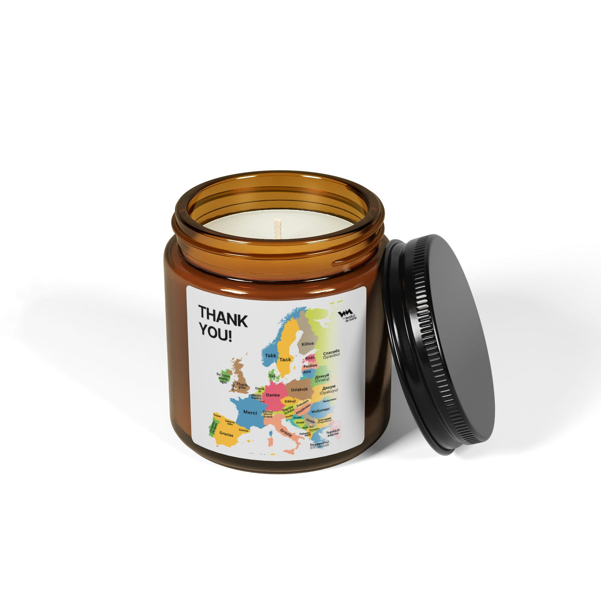 Thank You soy candle in an amber jar with its black lid off, showing the Europe map label
